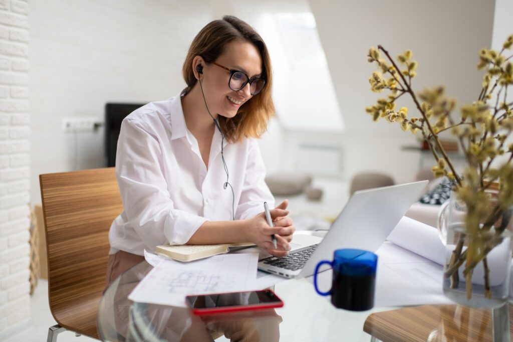 Positive female architect discussing project with client during online meeting