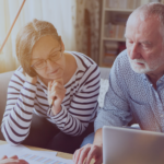 Older couple reviewing financial documents and discussing retirement plans.