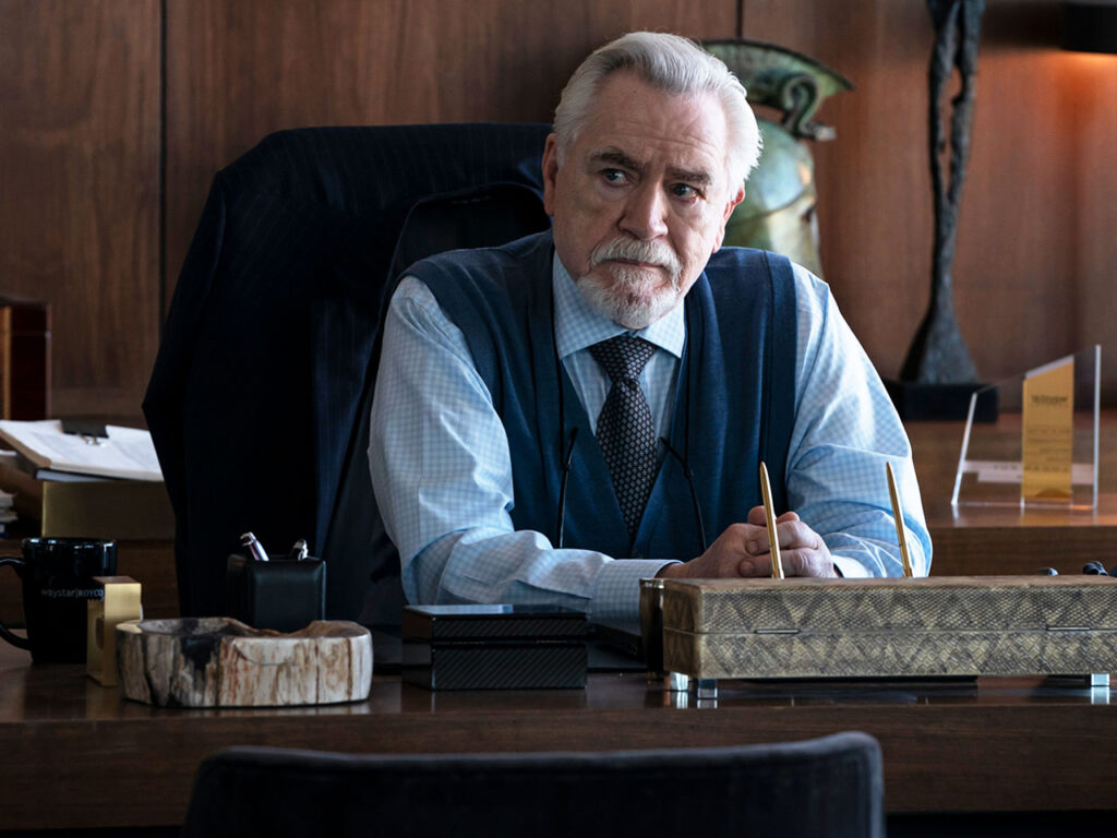 Senior business executive seated at a desk in a corporate office, conveying authority, leadership responsibility, and themes of succession planning and control in a family-owned business.